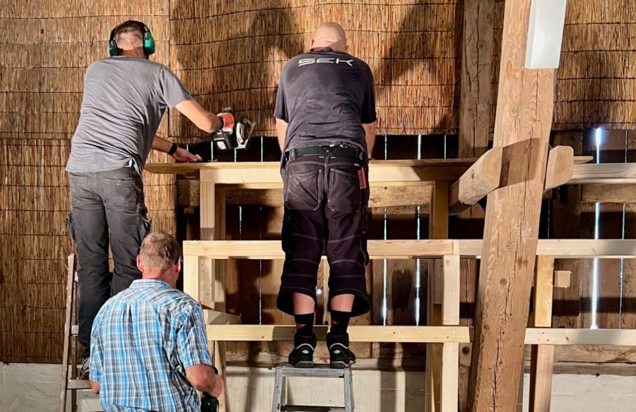 Gruppenaktivität beim Bau einer Veranstaltungstribüne in der Scheune